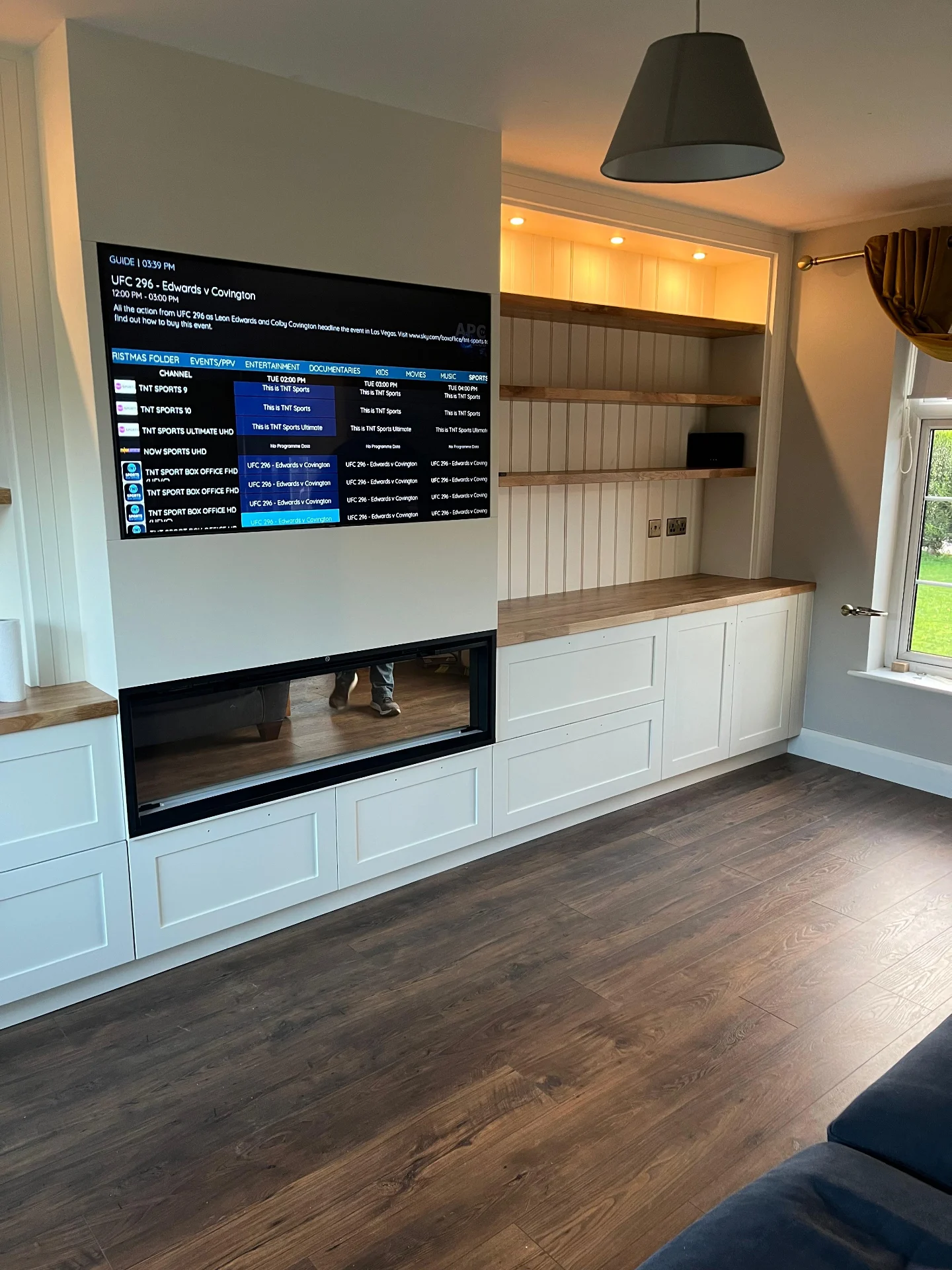 Living room media wall with fitted display shelving and integrated storage.