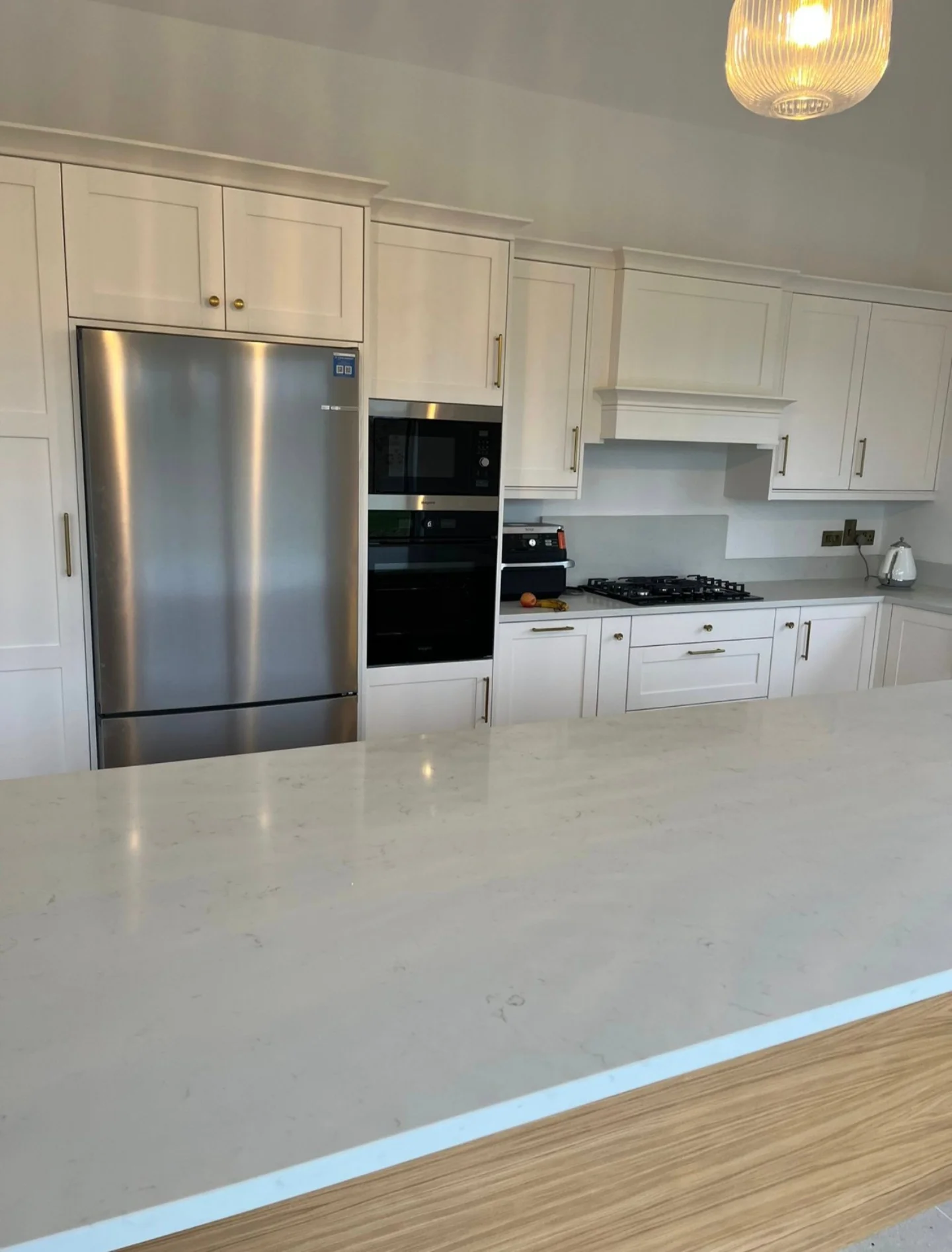 Cream fitted kitchen with a black range cooker, stone worktops and natural light.